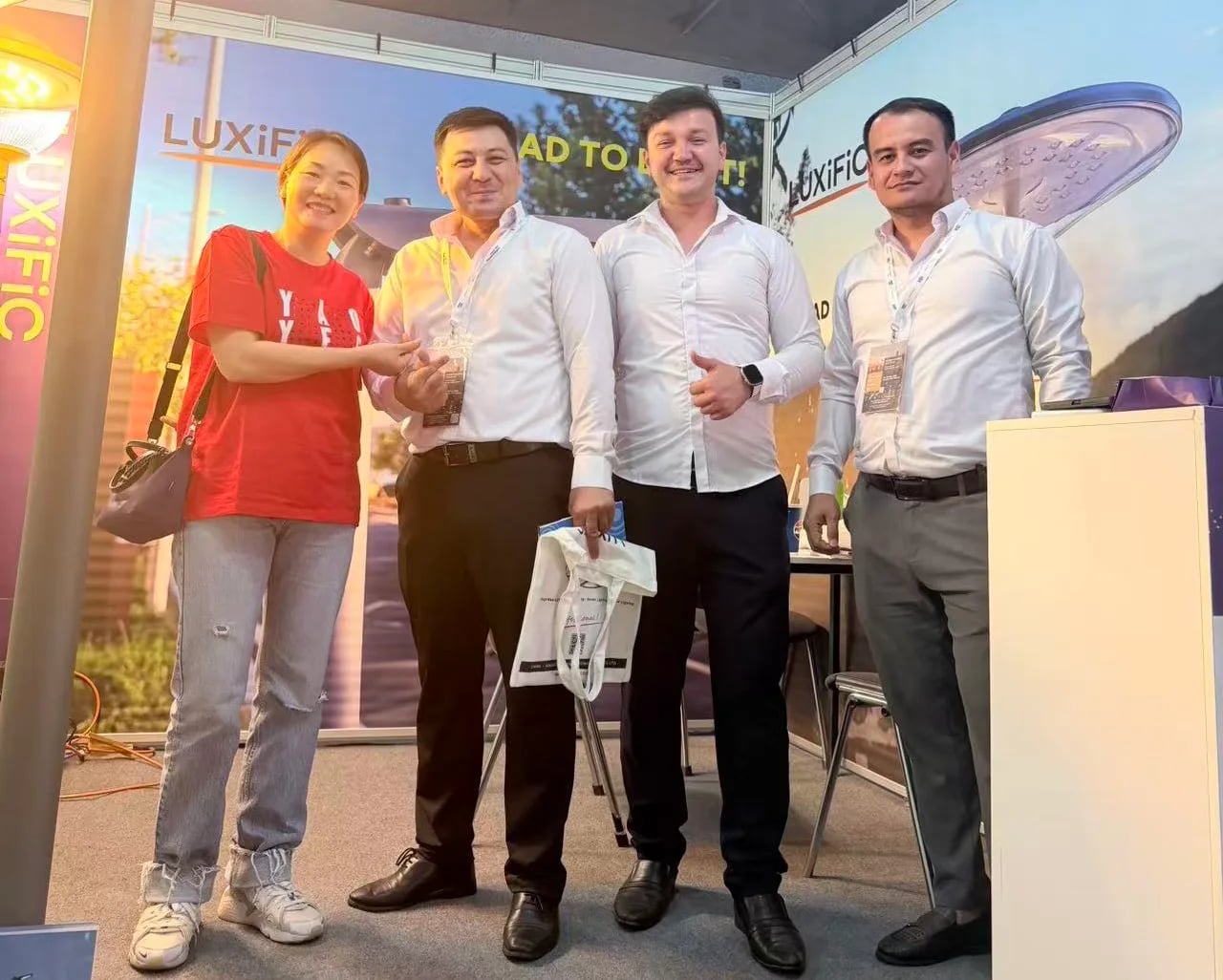 Visitors meeting at the LUXiFiC exhibition stand with outdoor lighting displays